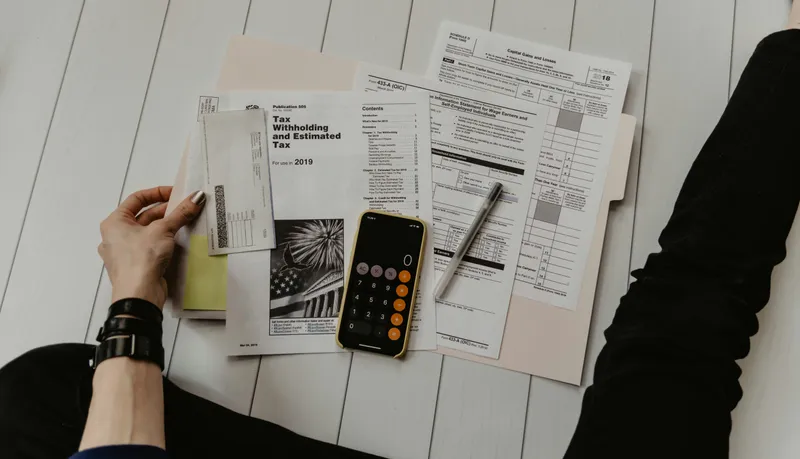 Confused homebuyer calculating Mello-Roos tax, property expenses, and new construction housing costs with receipts and calculator.