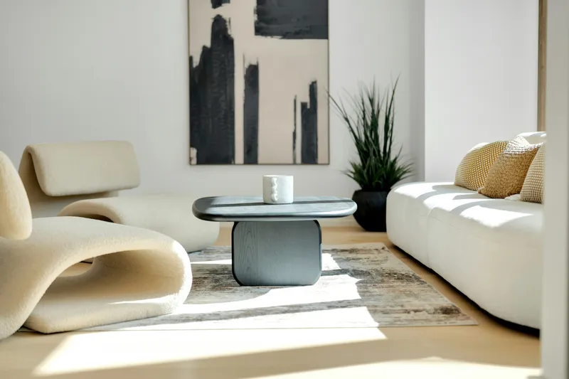 Clean modern living room with a neutral sectional sofa and warm natural light — well-staged interior
