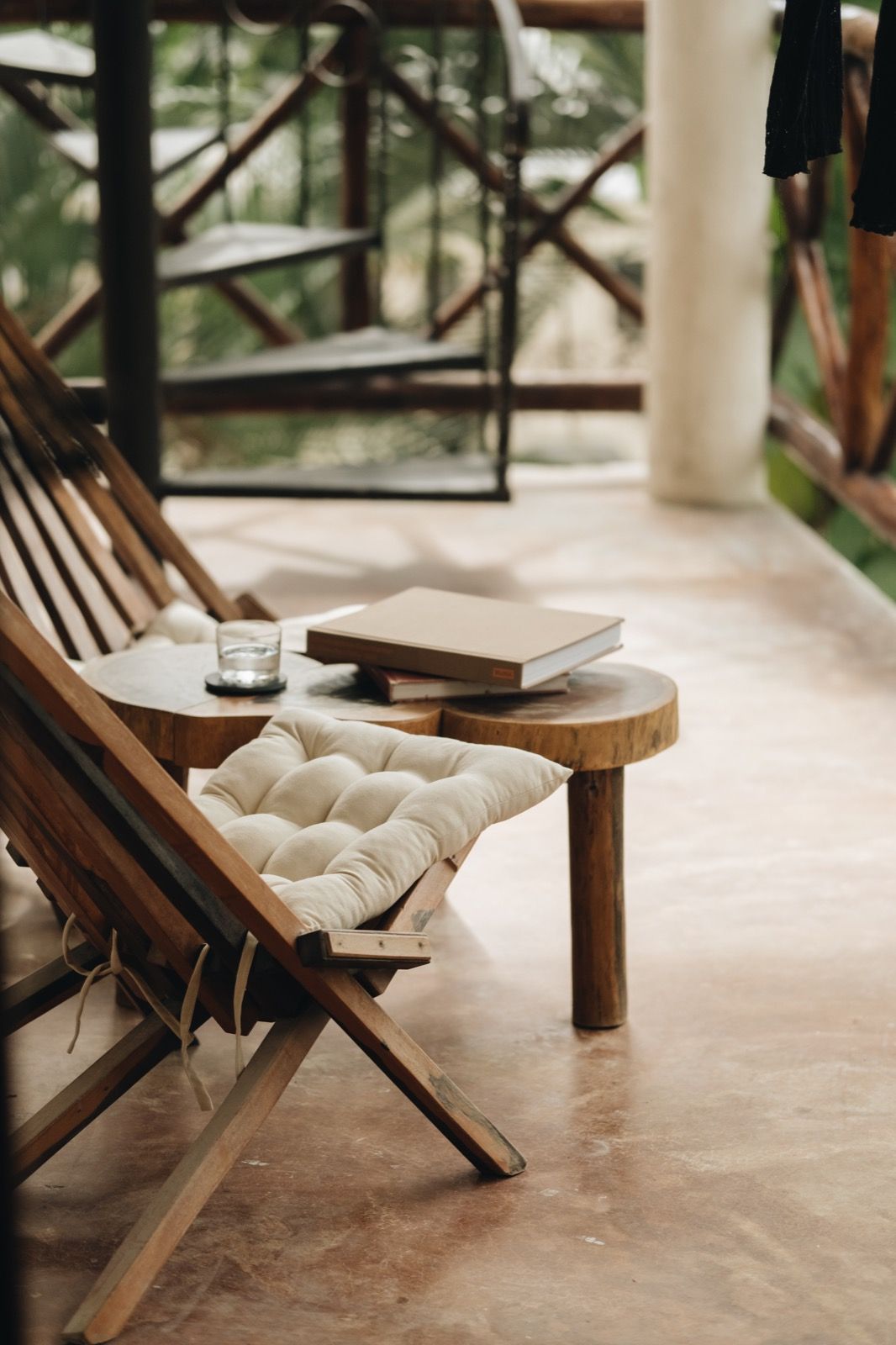 Wooden chair and table with a book on a sunlit porch — invitation to home